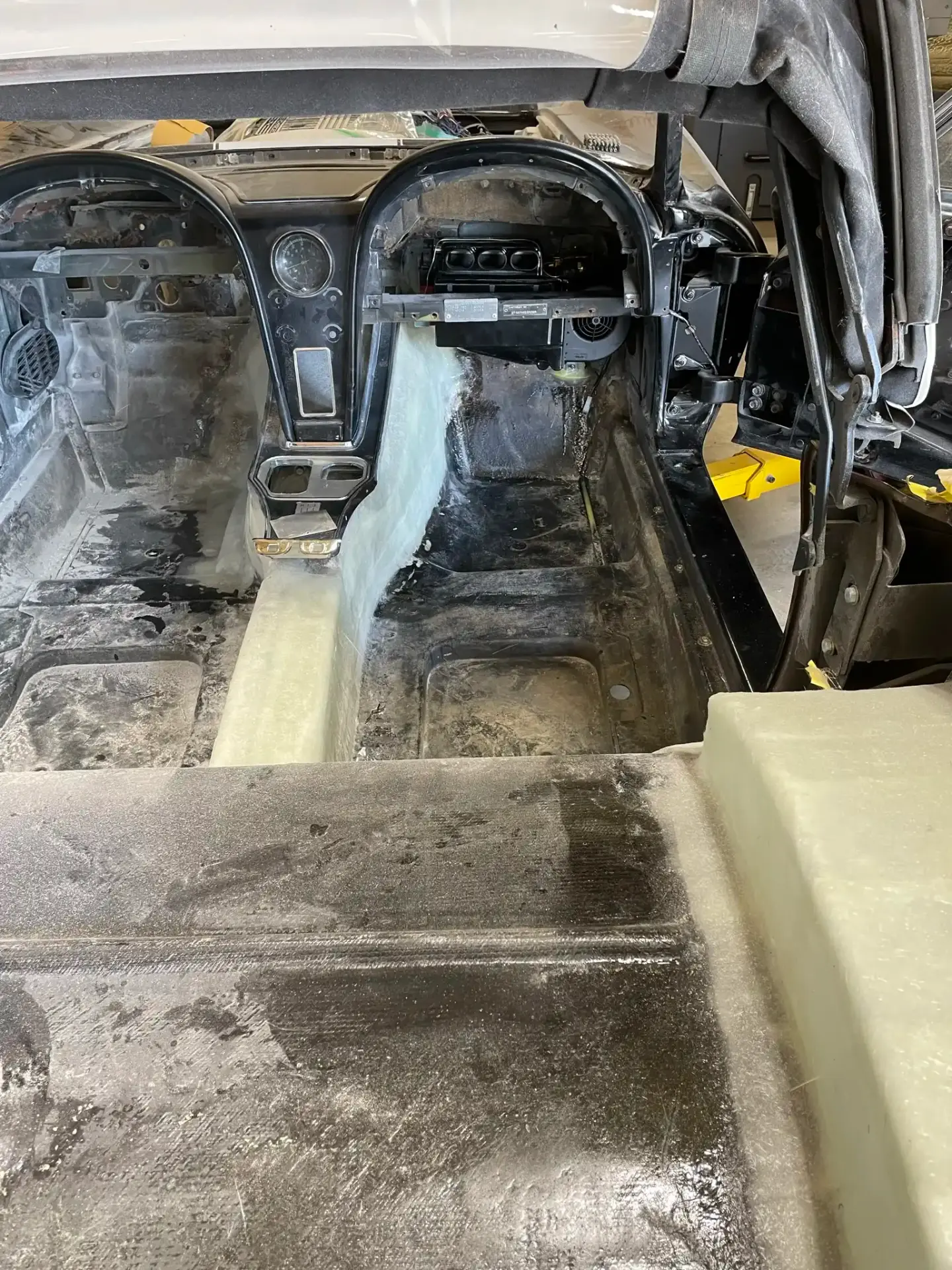 Stripped interior with console tunnel and dash during bodywork